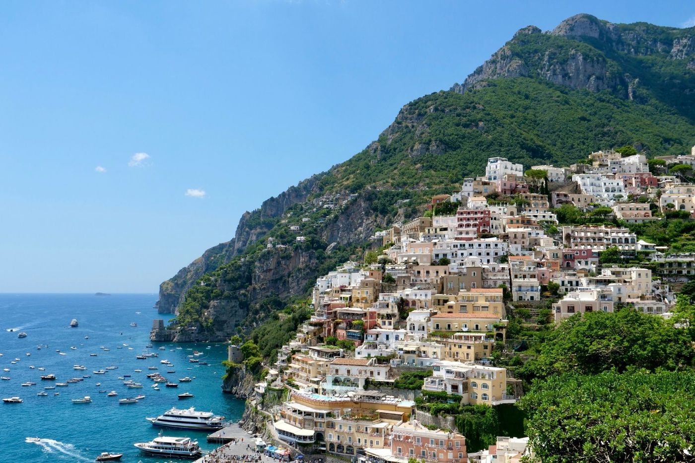 Panoramic view of Positano's colourful cliffside buildings cascading to the blue Tyrrhenian Sea on the Amalfi Coast walking holiday, Italy